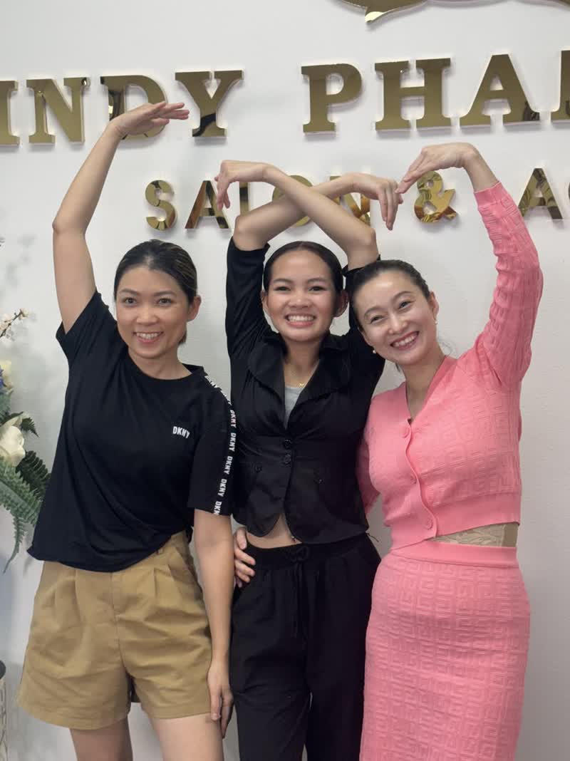 Ba học viên tạo hình trái tim trước bảng hiệu Cindy Phan